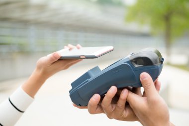 Fatura ödeme için cep telefonu kullanan kadın