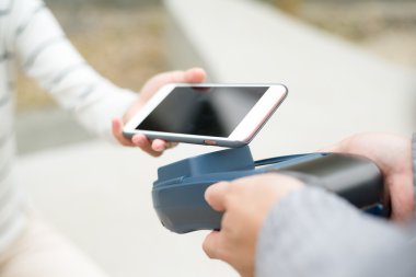 Fatura ödeme için cep telefonu kullanan kadın