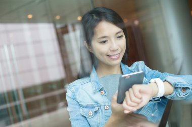 Kadın akıllı izlemek ve cep telefonu bağlantı