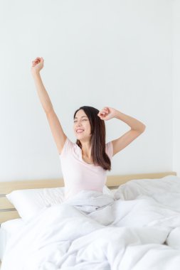 Uyandıktan sonra yatakta uzanan bir kadın.