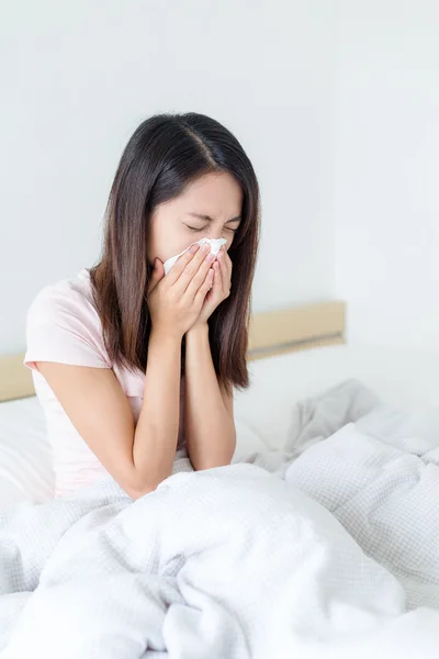 Mujer que se enfría y estornuda en la cama — Foto de Stock