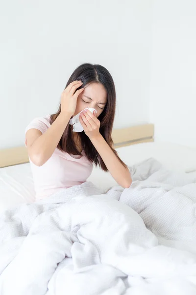 Wanita mendapatkan dingin dan bersin di tempat tidur — Stok Foto