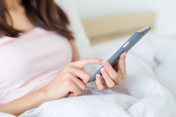 Wanita menggunakan ponsel di tempat tidur — Stok Foto