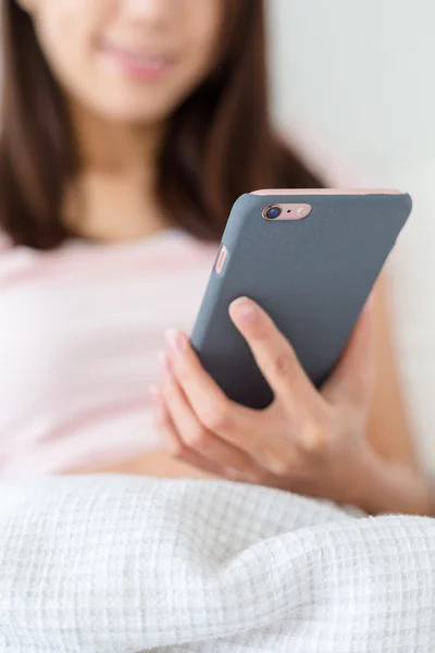 Frau benutzte Handy im Bett — Stockfoto