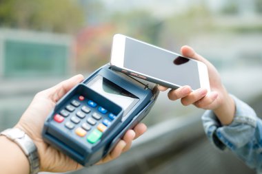 Fatura ödeme için cep telefonu kullanan kadın