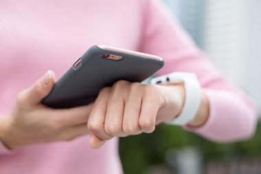 Kadın akıllı izlemek ve cep telefonu bağlantı