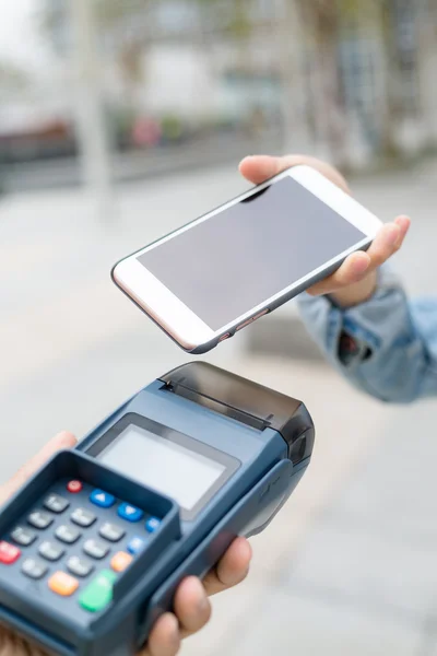 Klant met behulp van de mobiele telefoon naar de kassa — Stockfoto