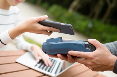 Fatura ödeme için cep telefonu kullanan kadın