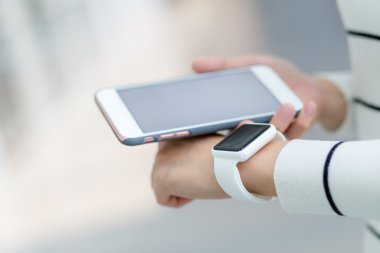 Kadın akıllı izlemek ve cep telefonu bağlantı