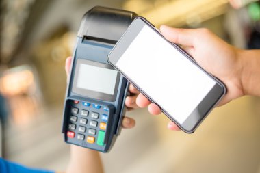 Woman using smart phone for paying the bill