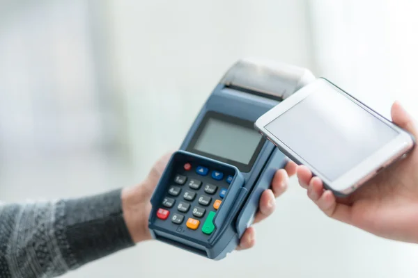 Vrouw met behulp van de mobiele telefoon voor het betalen van de rekening — Stockfoto