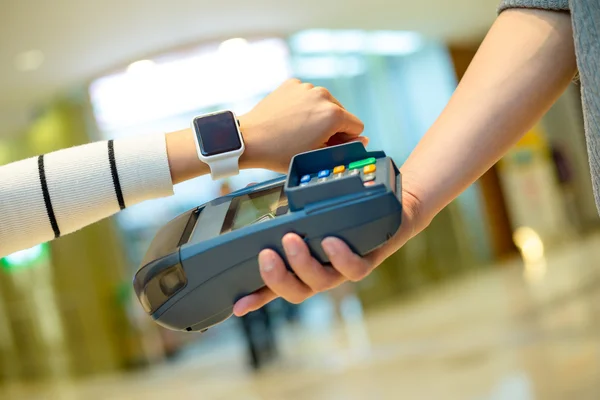 Mujer pagando la cuenta con un reloj inteligente — Foto de Stock