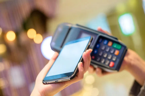 Mujer usando el teléfono celular para pagar la factura — Foto de Stock