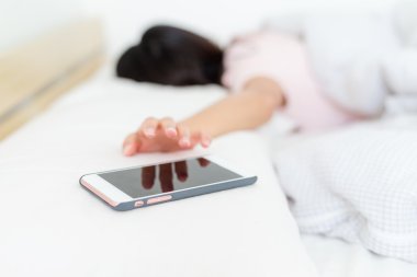 Kadın cep telefonu alarmı durdurmak için çalışıyor