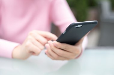 Açık café'de cep telefonu kullanan kadın