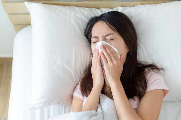 woman feeling unwell and lying in bed