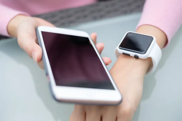 Femme connectant montre intelligente et téléphone portable — Photo