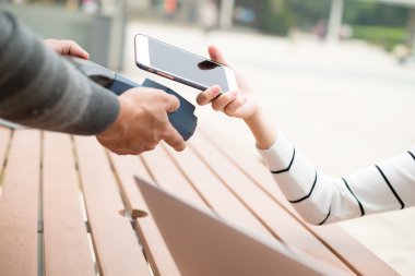 Woman using smart phone for paying the bill