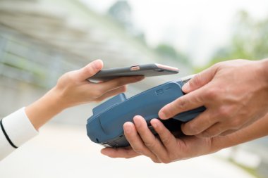 Woman using smart phone for paying the bill