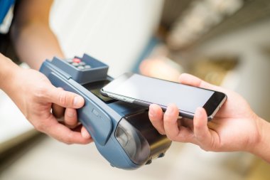 Fatura ödeme için cep telefonu kullanan kadın