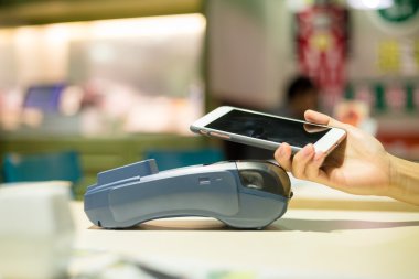 Fatura ödeme için cep telefonu kullanan kadın