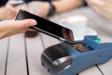 Fatura ödeme için cep telefonu kullanan kadın