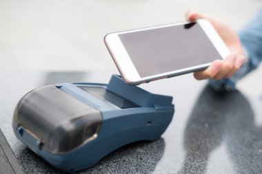 Fatura ödeme için cep telefonu kullanan kadın