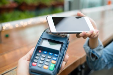 Fatura ödeme için cep telefonu kullanan kadın