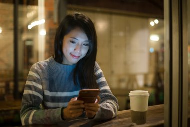 kahve dükkanında cep telefonu kullanan kadın