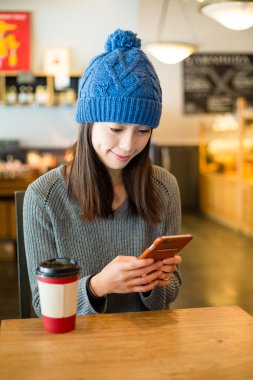 Kahve dükkanında cep telefonu kullanan kadın