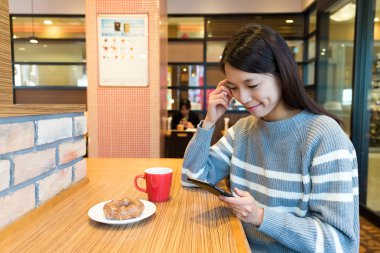 kahve dükkanında cep telefonu kullanan kadın