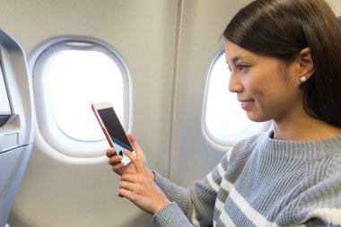 uçak içinde cep telefonu kullanan kadın