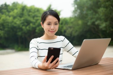 cep telefonu ve dizüstü bilgisayar kullanan kadın  