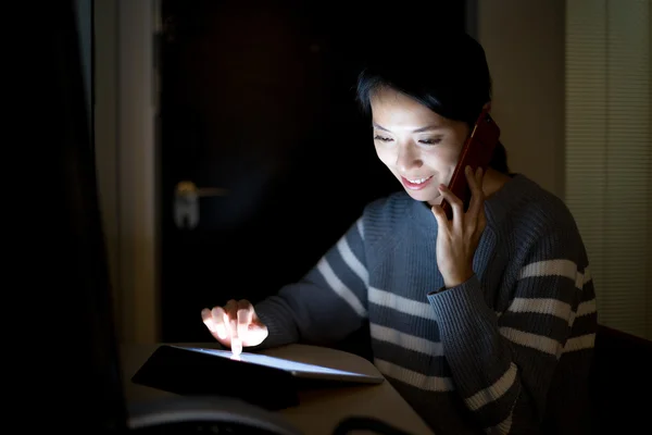 Kvinna med hjälp av tablet pc och talar i mobiltelefon — Stockfoto