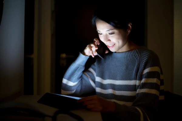 Kvinna med hjälp av tablet pc och pratar i mobiltelefon — Stockfoto