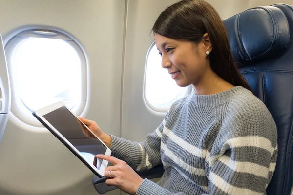 Vrouw met behulp van tablet pc binnen vliegtuigen — Stockfoto