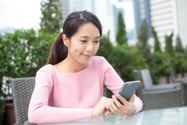 Açık café'de cep telefonu kullanan kadın