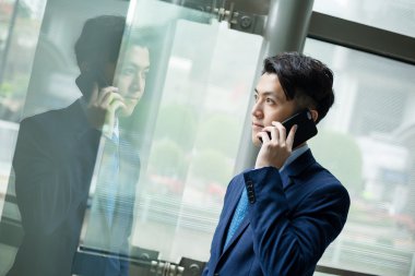 İş adamı cep telefonuyla konuşuyor.