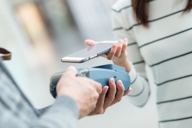 Fatura ödeme için cep telefonu kullanan kadın