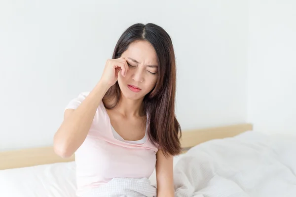 Wanita merasa sakit kepala dan duduk di tempat tidur — Stok Foto