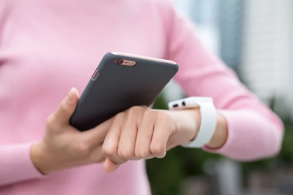 Woman connecting  smart watch with cellphone — Stock Photo, Image