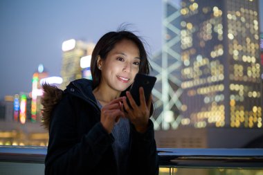 Geceleri cep telefonu kullanan kadın 