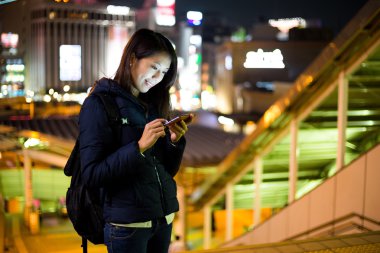 Geceleri cep telefonu kullanan bir kadın. 