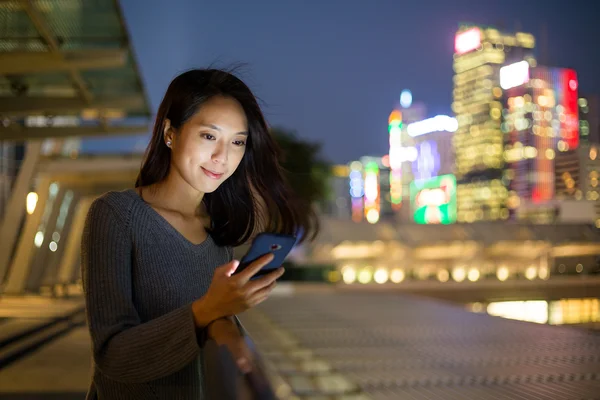 Женщина, использующая мобильный телефон ночью — стоковое фото