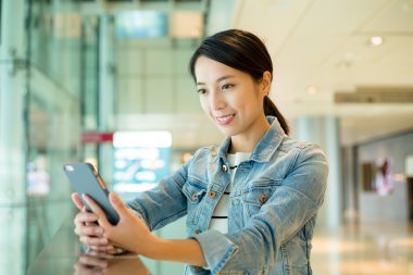 Asyalı genç kadın cep telefonu kullanarak