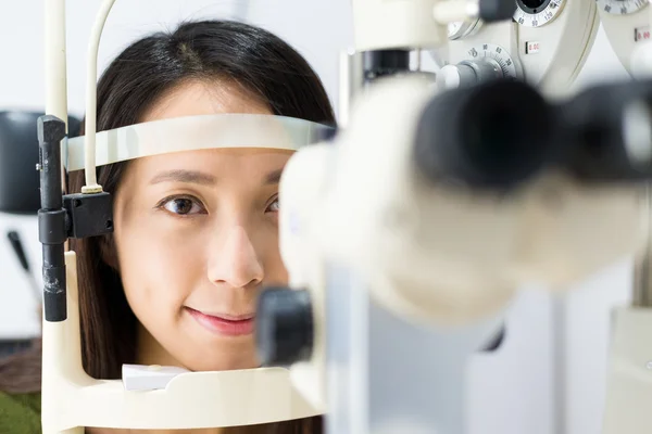 Mujer haciendo pruebas oculares en clínica óptica — Foto de Stock