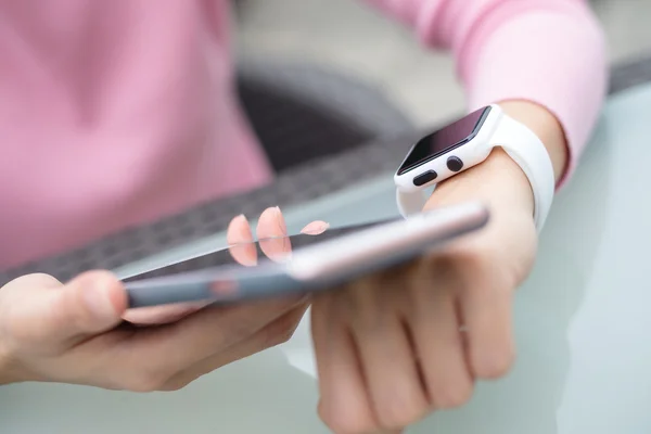 Vrouw met behulp van mobiele telefoon te verbinden met slimme horloge — Stockfoto