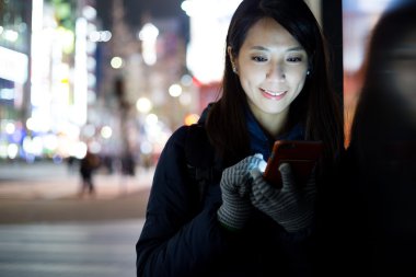 Akşamları akıllı telefon kullanan kadın.