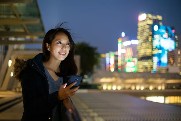 Mujer usando el teléfono celular por la noche — Foto de Stock