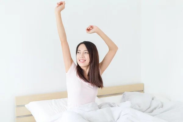 woman waking up in morning and stretching